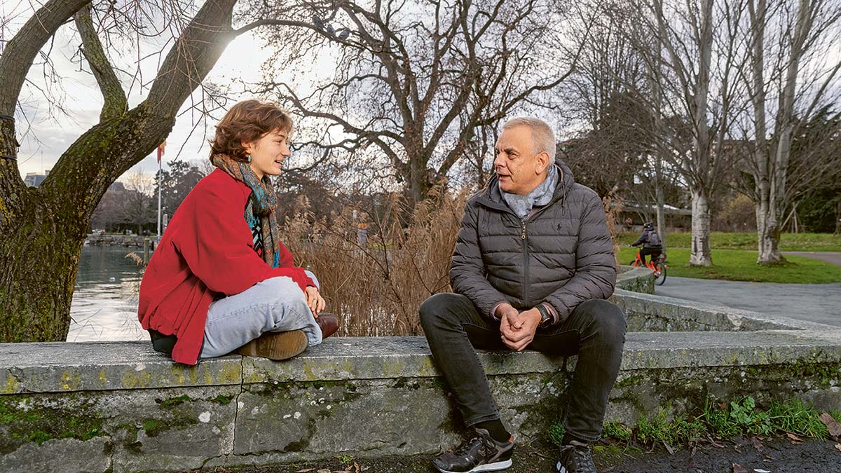 Lila Gonzenbach und Jean-Paul Schindelholz sitzen auf einer Steinmauer